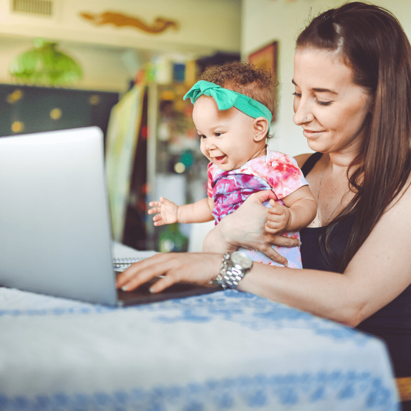 Young woman and baby girl sitting at a laptop